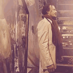 a man with a scarf around his neck is standing in front of a mirror
