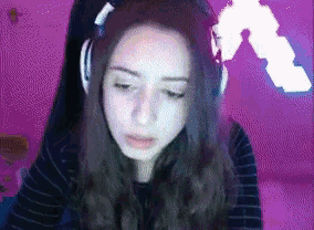 a girl wearing headphones and a striped shirt looks at the camera .