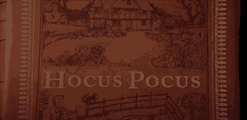 the word hocus pocus is glowing in the dark on a brown background .