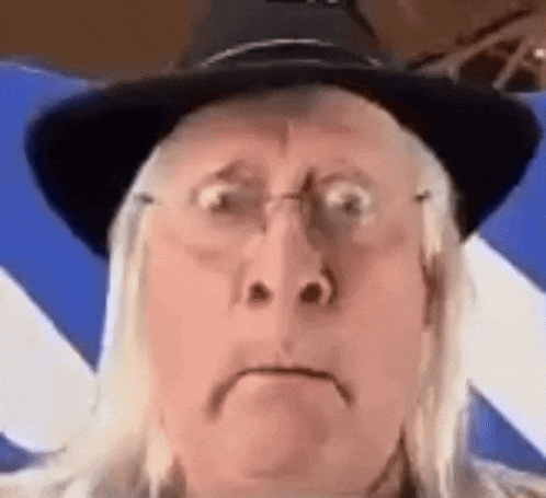 the man is wearing a hat and glasses and making a funny face .
