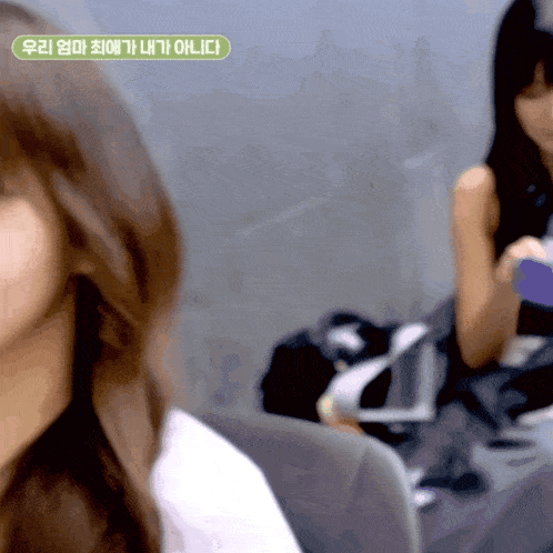 a blurred image of a woman with a green sticker that says " 우리 엄마 최 애가 내가 아니다 "