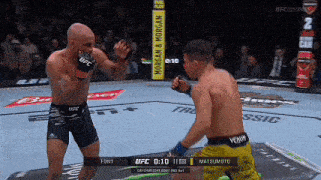 two men are fighting in a ufc ring with a sign that says morgan & morgan in the background