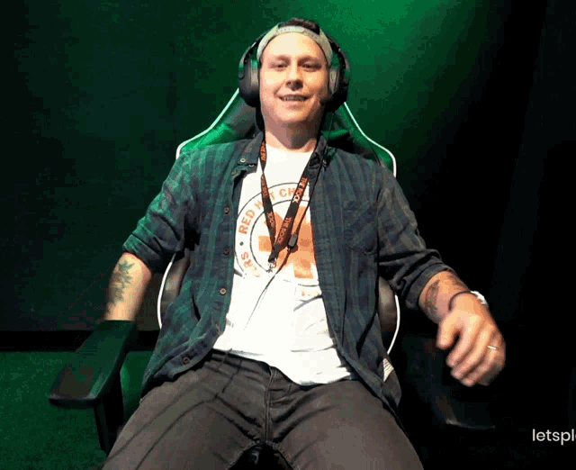 a man wearing headphones and a shirt that says red cross on it