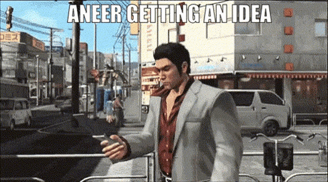 a man in a suit is walking down a street while looking at his phone with the caption " aneer getting an idea "