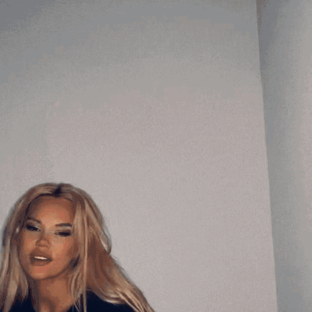 a blurry picture of a woman 's face with blonde hair blowing in the wind