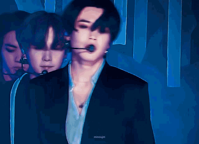 a blurry photo of a man in a suit with a microphone in his mouth and the name mincojin on the bottom