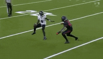 two football players are playing a game on a field . one of the players is wearing a number 8 jersey .