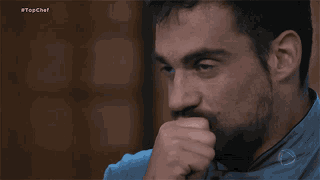 a man with a beard is waving his hand in front of another man .
