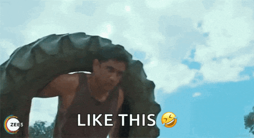 a man is carrying a tire on his back with the words `` like this '' next to him .