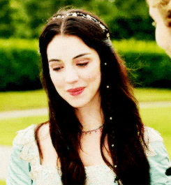 a woman wearing a headband with pearls on it is smiling