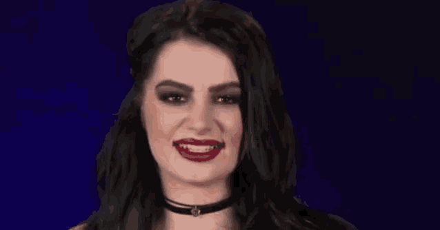 a woman with black hair and red lipstick is making a face .