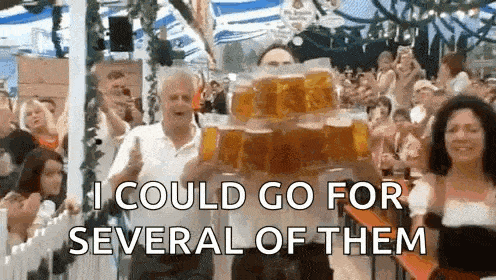 a man is carrying a stack of beer mugs in front of a crowd .