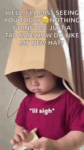 a little girl wearing a cardboard bag on her head is making a sad face .