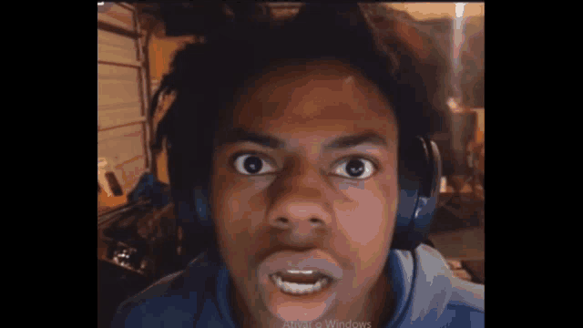 a young man wearing headphones is making a face