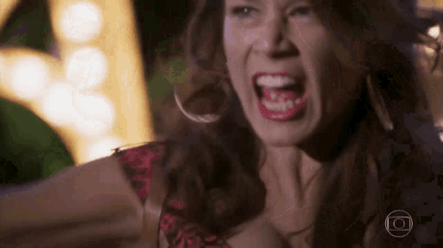 a woman is screaming with her mouth open in a dark room .