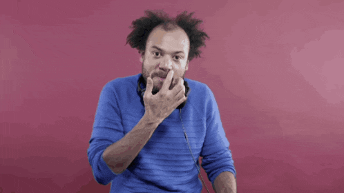 a man wearing headphones and a blue sweater is dancing