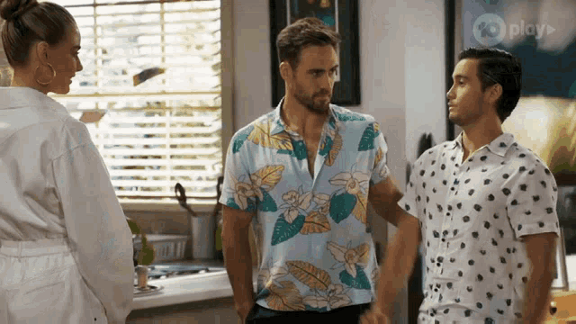 a man in a polka dot shirt stands next to a woman in a robe