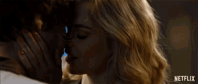 a man and a woman are kissing in a close up of a netflix ad .