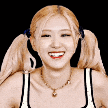 a woman wearing pigtails and a gold necklace with a bell on it