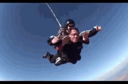 a man is flying through the air with a parachute .
