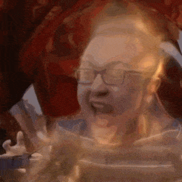 a close up of a woman wearing glasses making a funny face