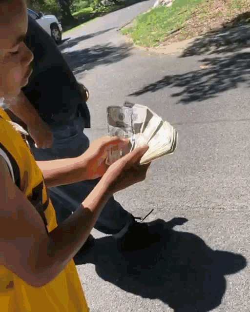a man in a yellow jersey is holding a large stack of money