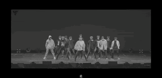 a group of people are standing on a stage dancing .