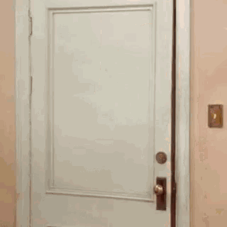 a woman in a yellow dress is standing in front of a door .