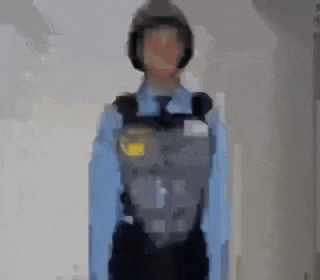 a blurry picture of a police officer wearing a helmet and a blue shirt .
