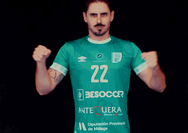 a man is wearing a green jersey with the number 22 on it