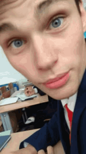 a young man in a suit and tie is taking a selfie