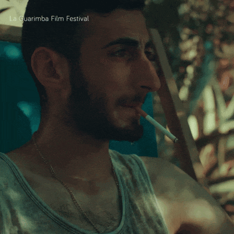 a man is smoking a cigarette with the words la guarimba film festival written below him