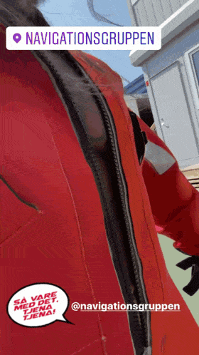 a person wearing a red jacket with the words navigationsgruppen written on it