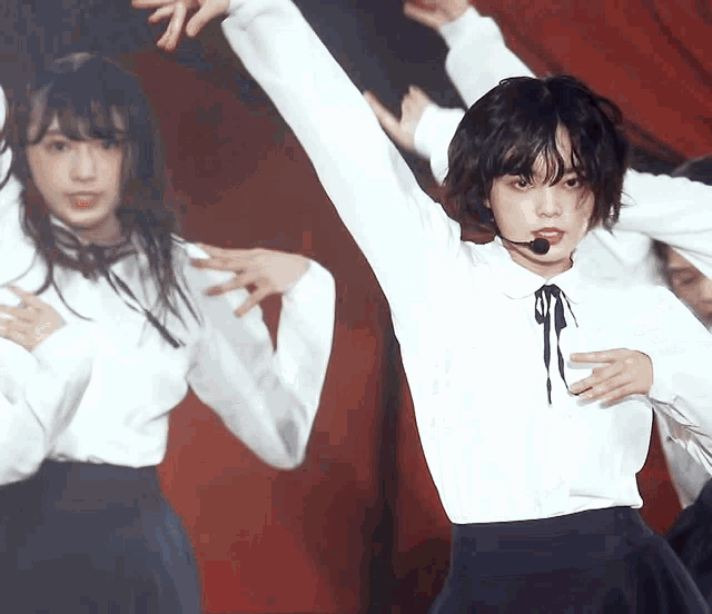 a girl wearing a microphone is dancing on stage
