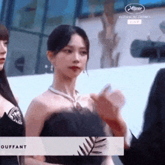 a woman in a black dress is talking to a man in a suit .