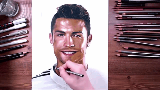a drawing of a man 's face is on a wooden table with colored pencils