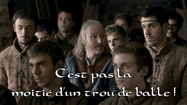 a group of men are standing in a line with the words " cest pas la moitie d' un trou de balle " on the bottom