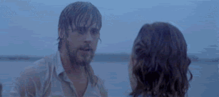 a man and a woman are standing next to each other in the water .
