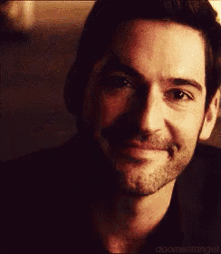 a man with a beard is smiling in a dark room .