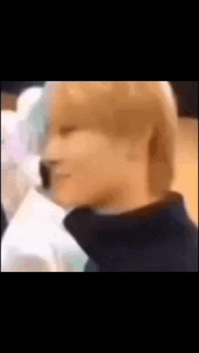 a blurry picture of a person 's face with a black jacket on .
