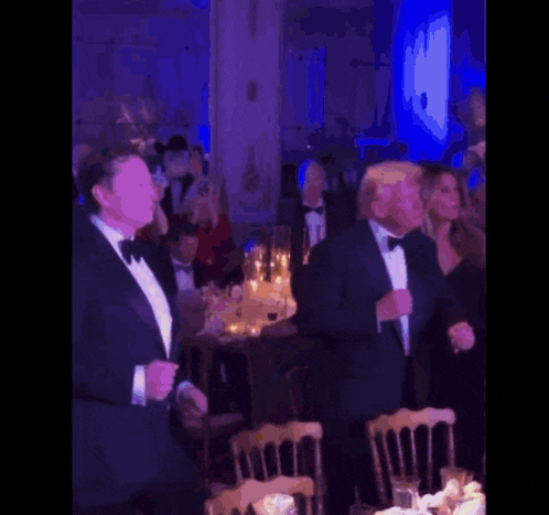 a man in a tuxedo is dancing in a crowd