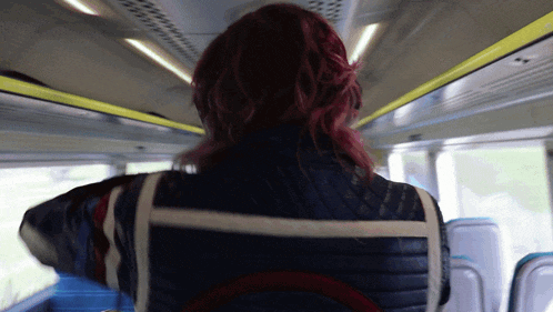 a woman with red hair is on a bus