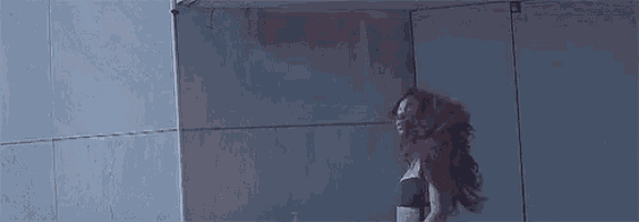 a woman is dancing in a room with her arms outstretched .