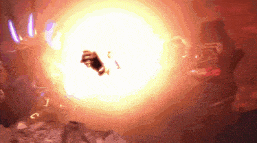 a person is standing in front of a large explosion in a dark room .
