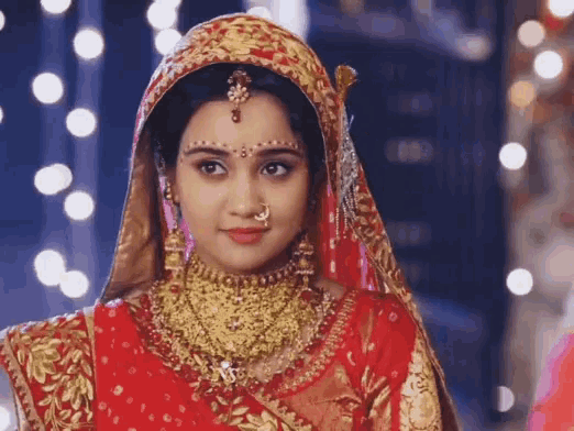 a woman in a red and gold dress and veil