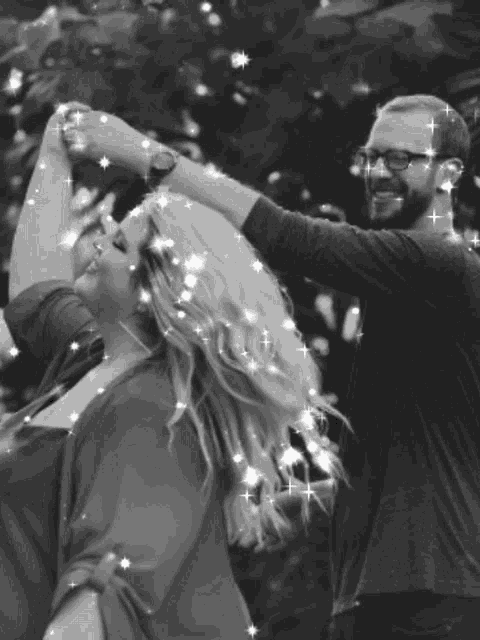 a man and a woman are dancing with sparklers in their hair