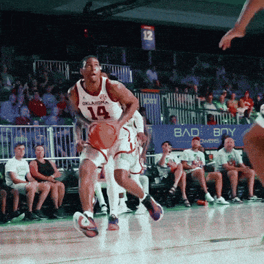 a basketball player wearing a oklahoma jersey dribbles the ball