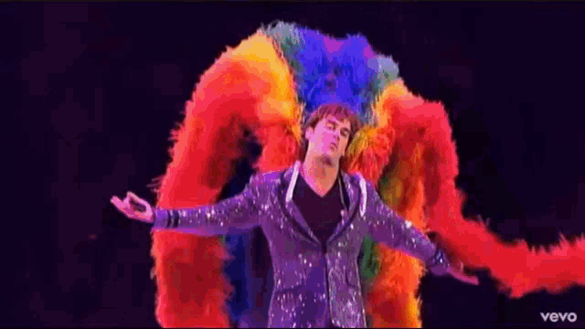 a man in a colorful costume with the word vevo on the bottom left
