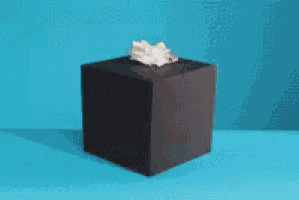 a hand is sticking out of a box and giving the middle finger .