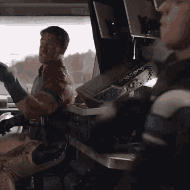 a man with blood on his face is sitting in the driver 's seat of a car